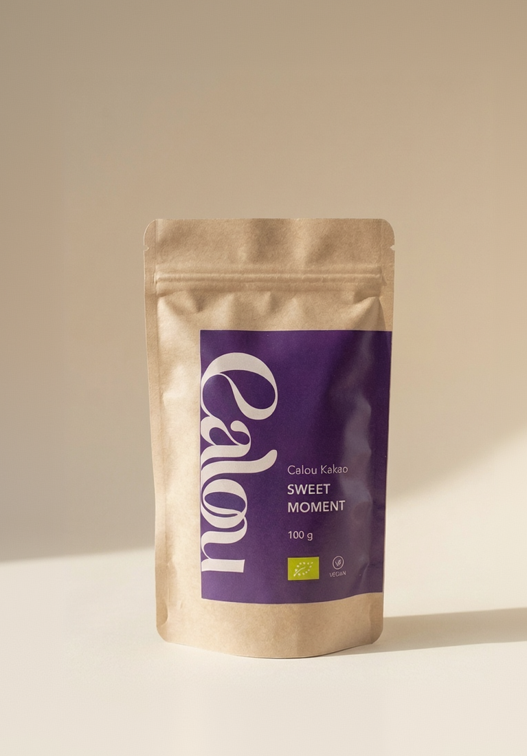100 g Packung ‚Calou Kakao Sweet Moment‘ in brauner Kraftpapierverpackung mit violettem Etikett vor beidem Hintergrund.